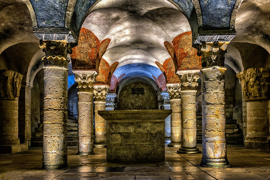 Ancient stone crypt with columns and medieval frescoes