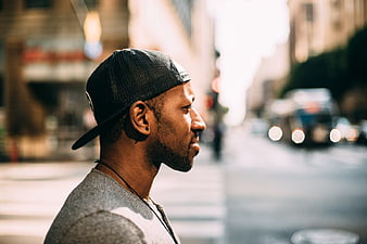 Profile of Black Man in Cap on City Street