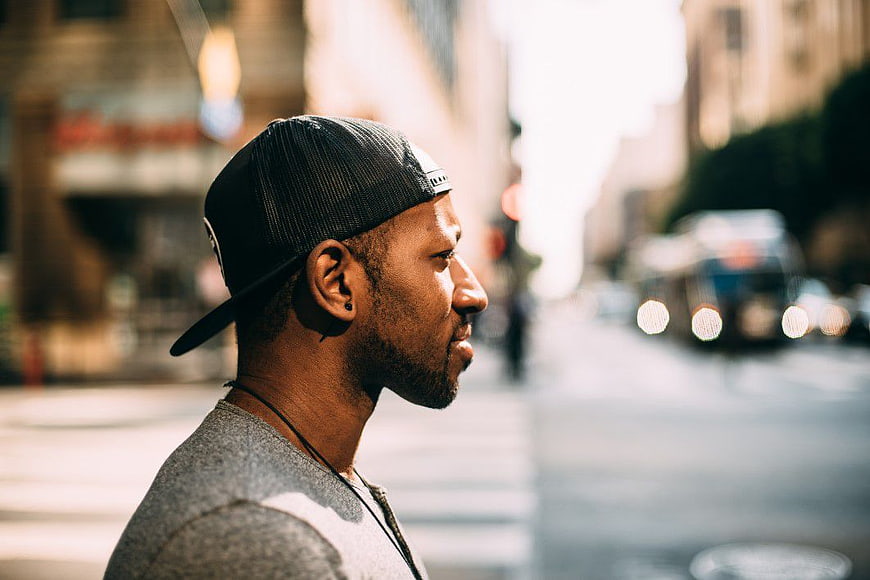 Profile of Black Man in Cap on City Street