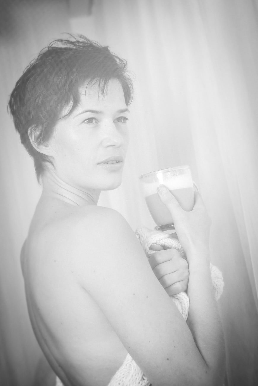 Woman with short hair holding coffee cup in black and white