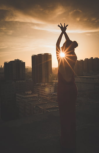 Woman Silhouette Dancing On Rooftop At Sunset