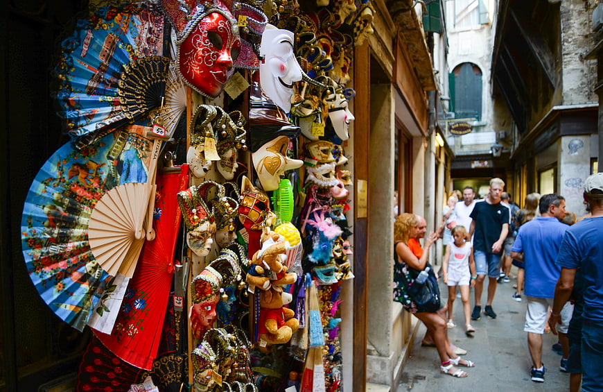 Venetian masks and fans in a narrow Italian street