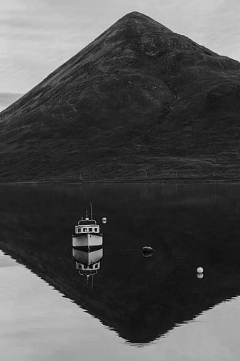Black and white boat reflection in calm fjord water