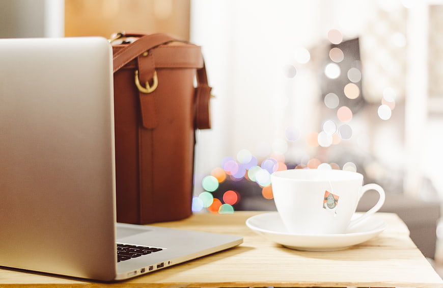 Laptop and Tea Cup on Desk with Bokeh Lights