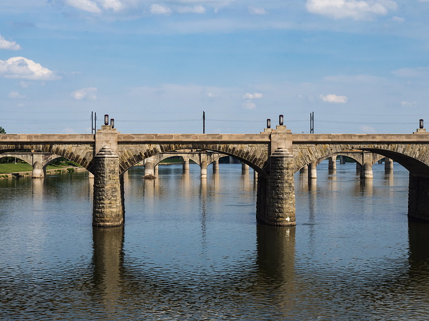 Stone Arch Bridge Spanning a River Under Blue Sky