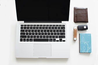 Top-Down View of White Desk with Laptop, Wallet, and Notebook