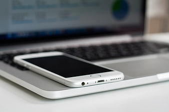 White Smartphone on Silver Laptop Keyboard