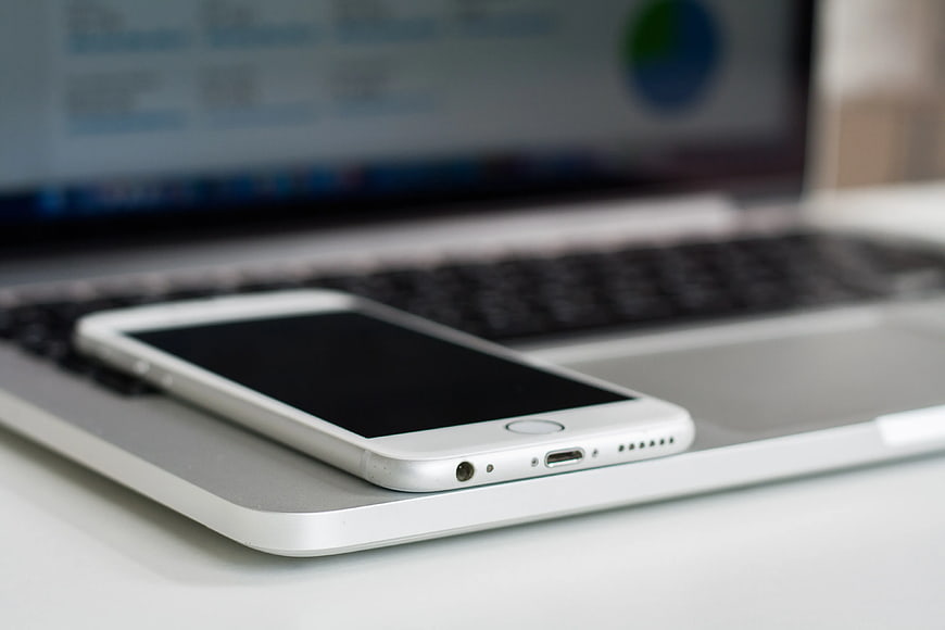 White Smartphone on Silver Laptop Keyboard