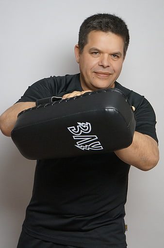 Portrait of a man holding a black punching pad