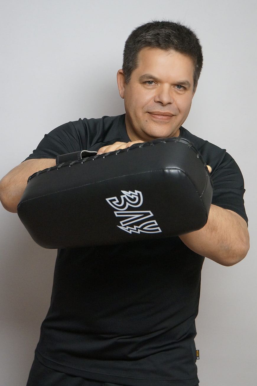 Portrait of a man holding a black punching pad