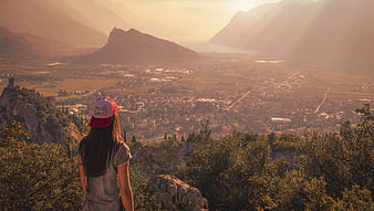 Woman in Red Cap Overlooking Hazy Mountain Valley at Sunset