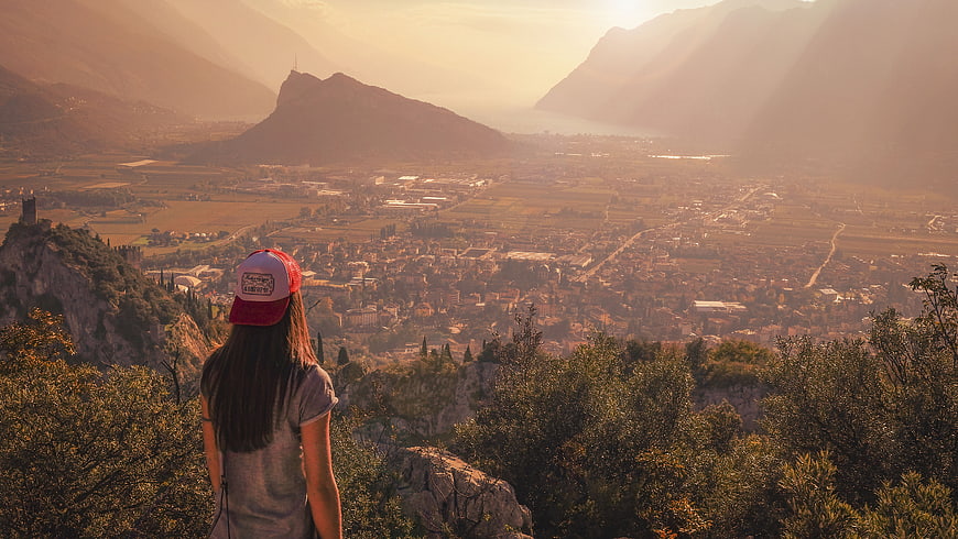 Woman in Red Cap Overlooking Hazy Mountain Valley at Sunset