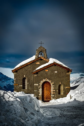 Snowy Mountain Chapel with Dramatic Sky