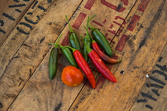Fresh red and green chili peppers on rustic wood