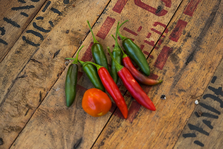 Fresh red and green chili peppers on rustic wood