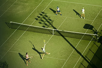 Aerial view of tennis doubles match on green court