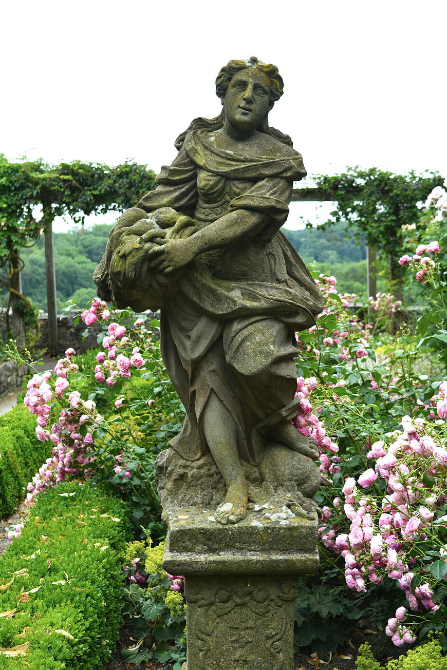 Classical Stone Statue in a Lush Rose Garden