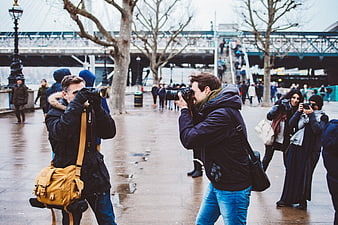 Photographers taking pictures on a rainy city street