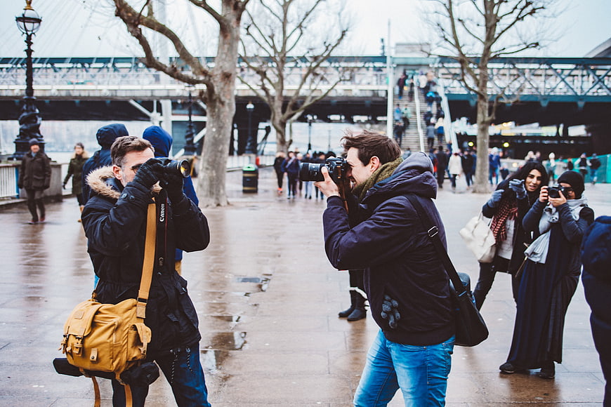 Photographers taking pictures on a rainy city street
