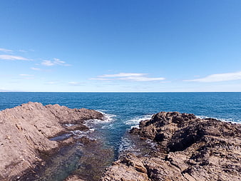Rugged Rocky Coastline with Blue Ocean and Clear Sky