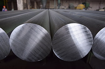 Close-up of polished steel rods in industrial factory setting