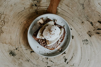 Overhead view of chocolate toast with banana and ice cream on rustic wood