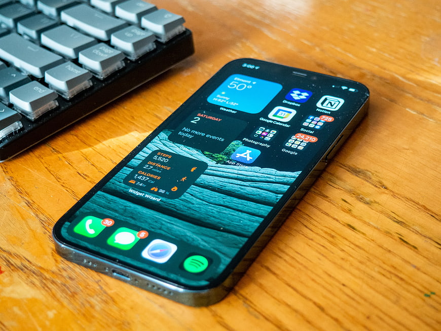 Smartphone with Widgets on Wooden Desk