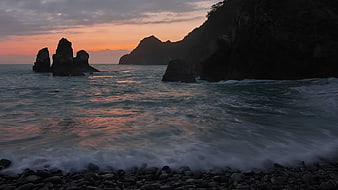 Dramatic Sunset Over Rocky Coastline with Sea Stacks