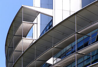 Modern curved office building with glass facade and metal sunshades