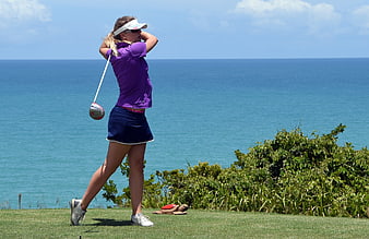 Woman Golfer Swinging Driver on Ocean View Course