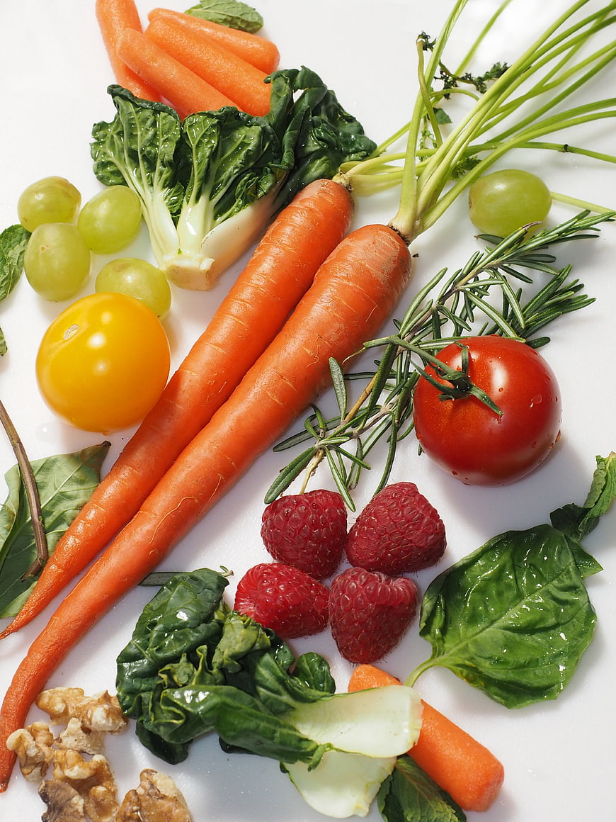 Fresh organic vegetables and fruits on white background