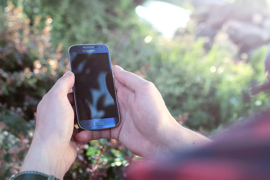 Hands Holding Blue Samsung Smartphone Outdoors