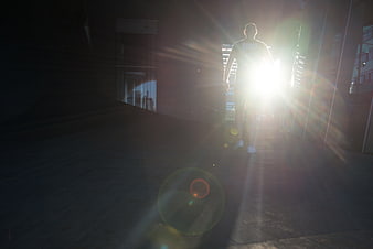 Silhouette of Man Walking Toward Bright Sunlight