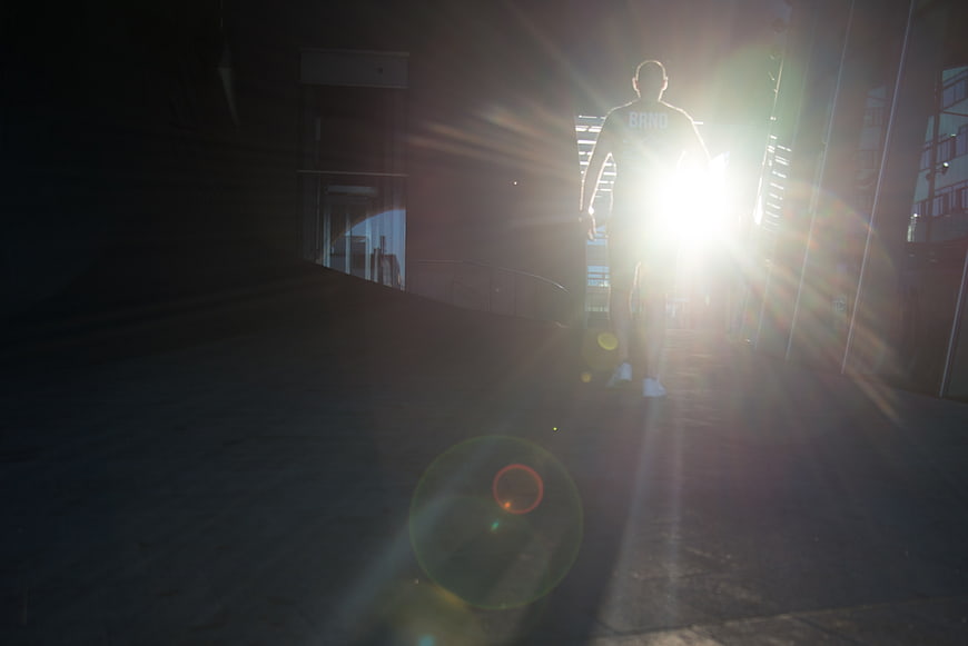 Silhouette of Man Walking Toward Bright Sunlight