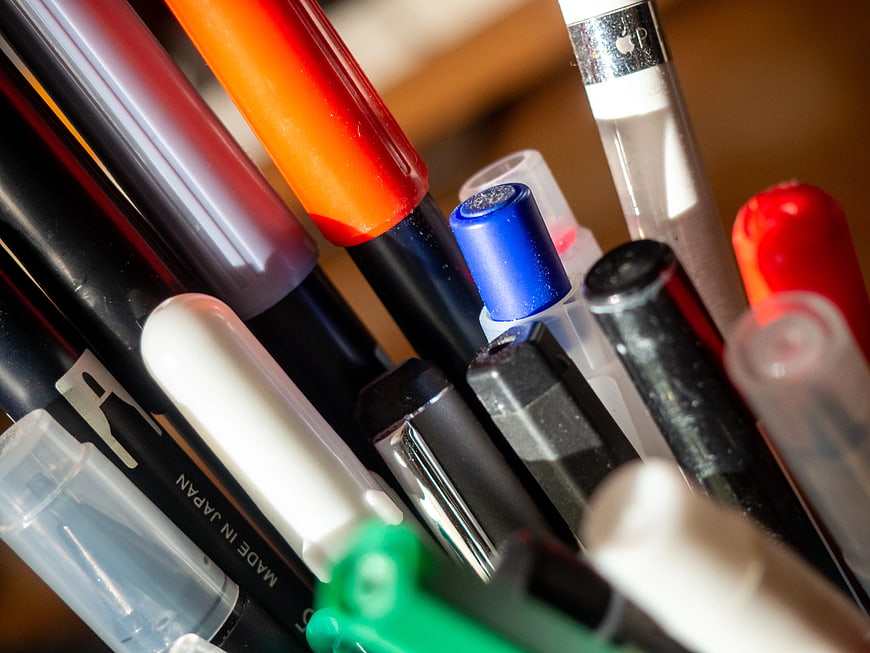 Close-up of colorful pens and markers in a holder
