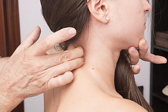Close-up of hands massaging a woman's neck and shoulders