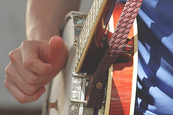 Close-up of hand playing banjo with leather strap