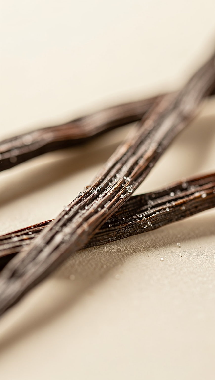 Close-up of Vanilla Beans with Sugar Crystals on Beige Background