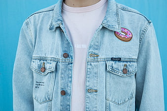 Close-up of light blue denim jacket with donut patch