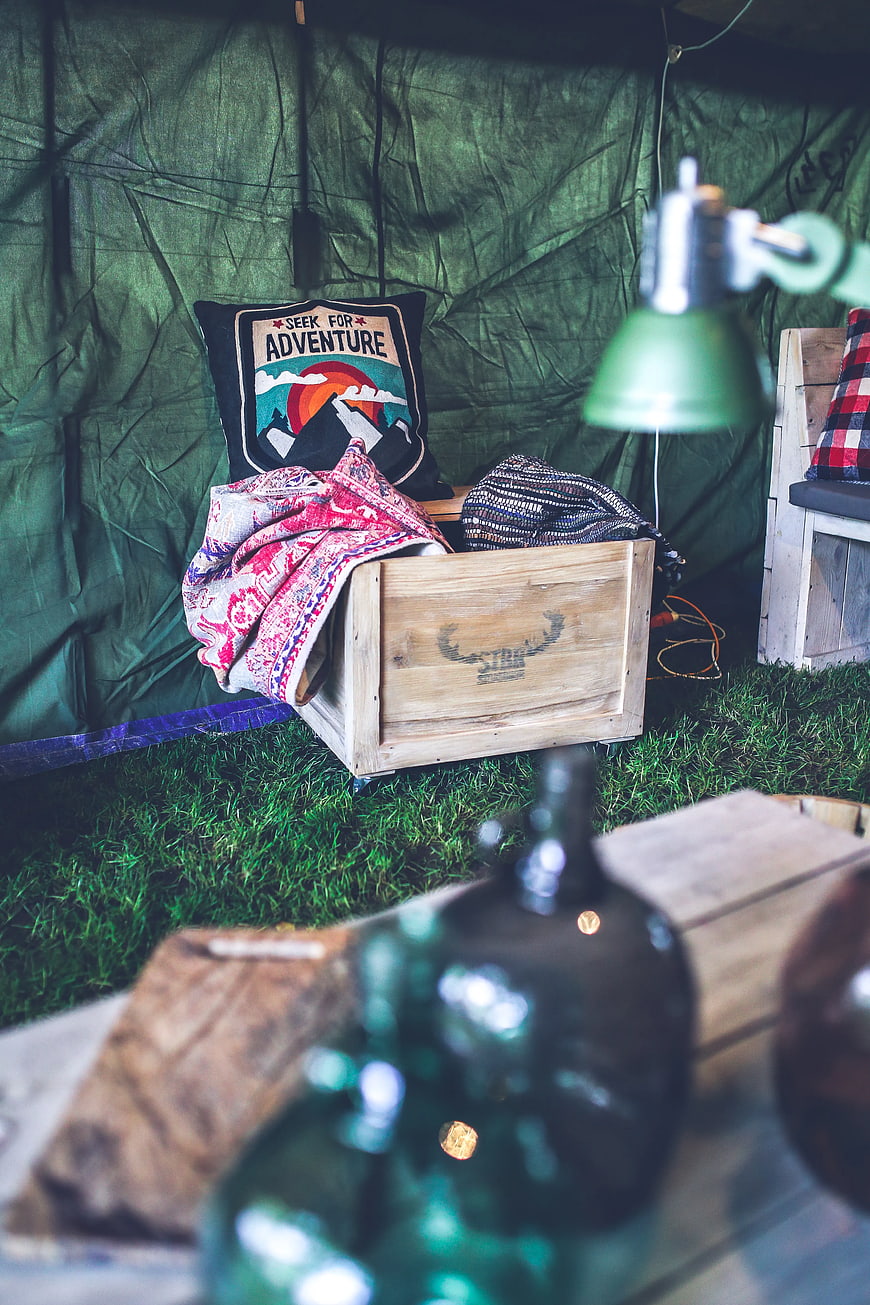 Cozy camping setup with wooden crate and adventure pillow