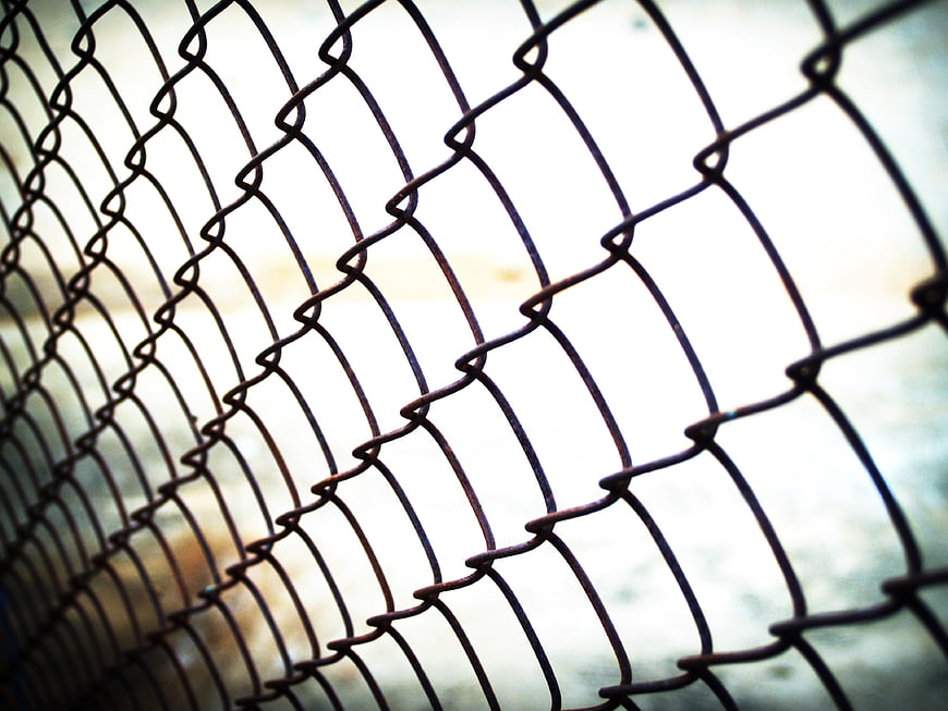 Close-up of rusty chain-link fence with shallow depth of field