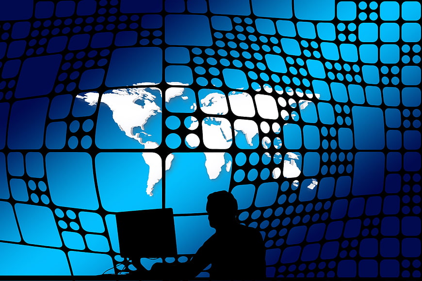 Silhouette of man at computer with global network and earth map background