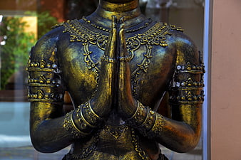 Golden Buddha Statue in Prayer Pose with Intricate Details