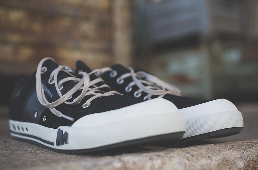 Black low-top sneakers on stone surface