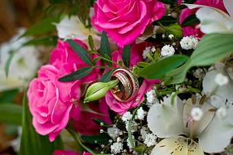Wedding rings nestled in pink rose bouquet