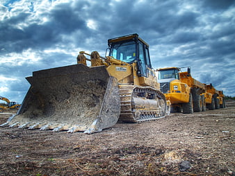 Heavy Construction Machinery on Site Under Dramatic Sky