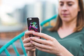 Woman using smartphone with colorful case outdoors