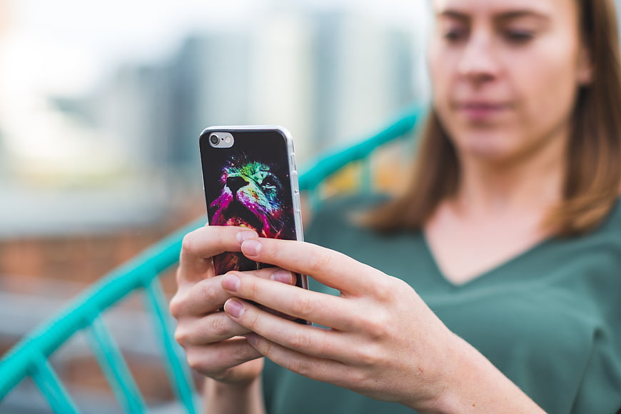 Woman using smartphone with colorful case outdoors