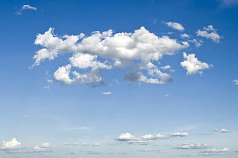 Fluffy white clouds against a bright blue sky