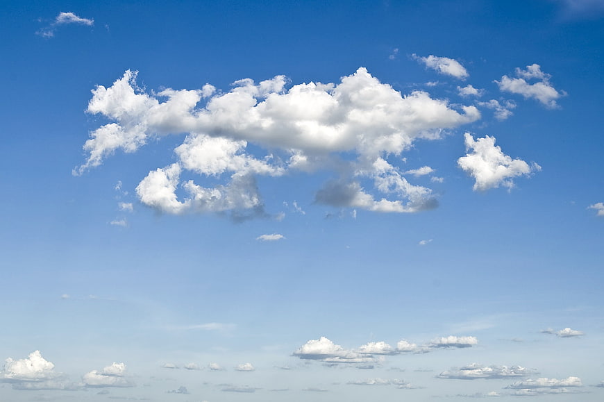 Fluffy white clouds against a bright blue sky